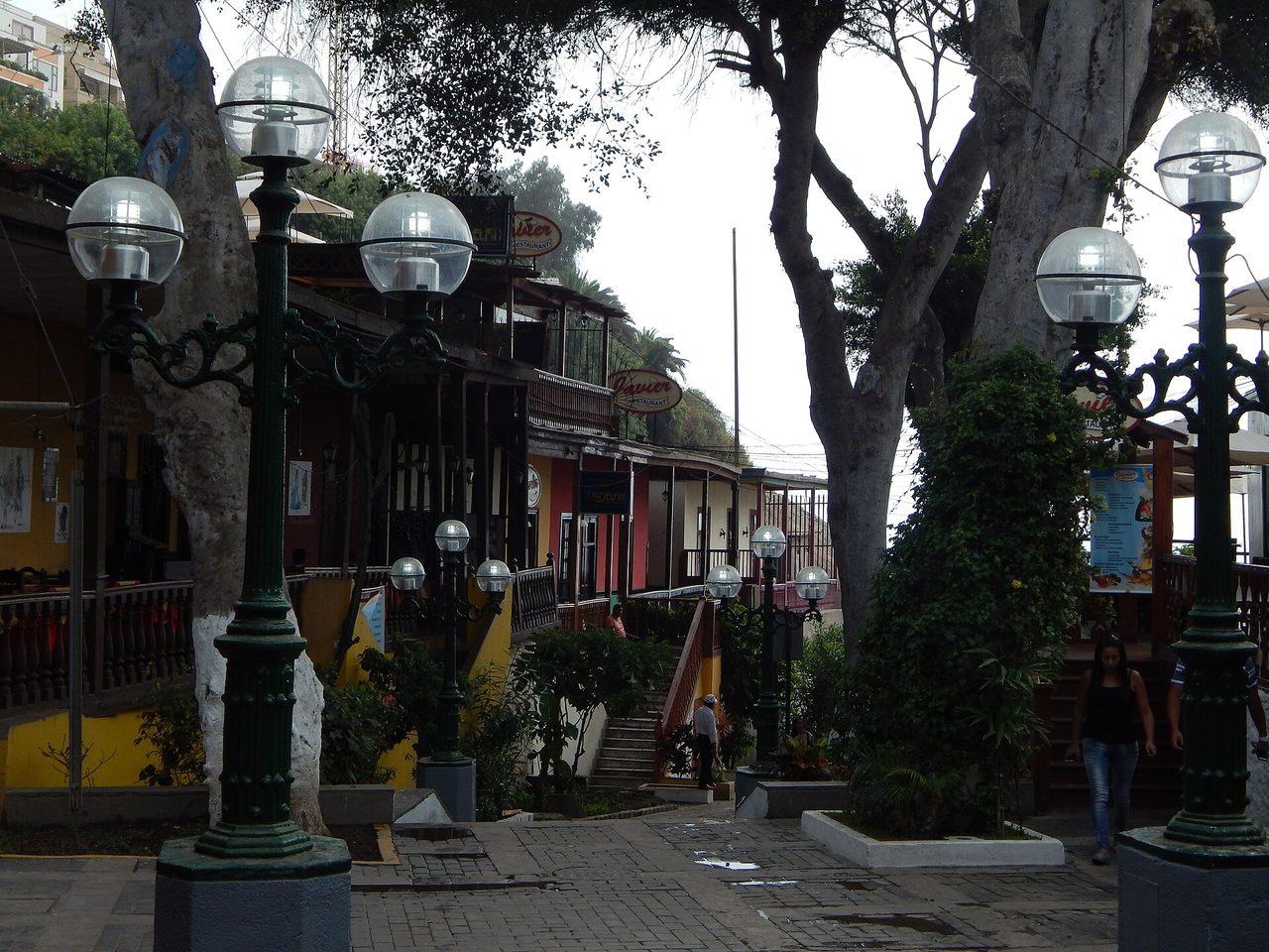 The Bajada de Banos in Barranco lined with old timber-balconied restaurants, green lampposts and steps heading down towards the sea
