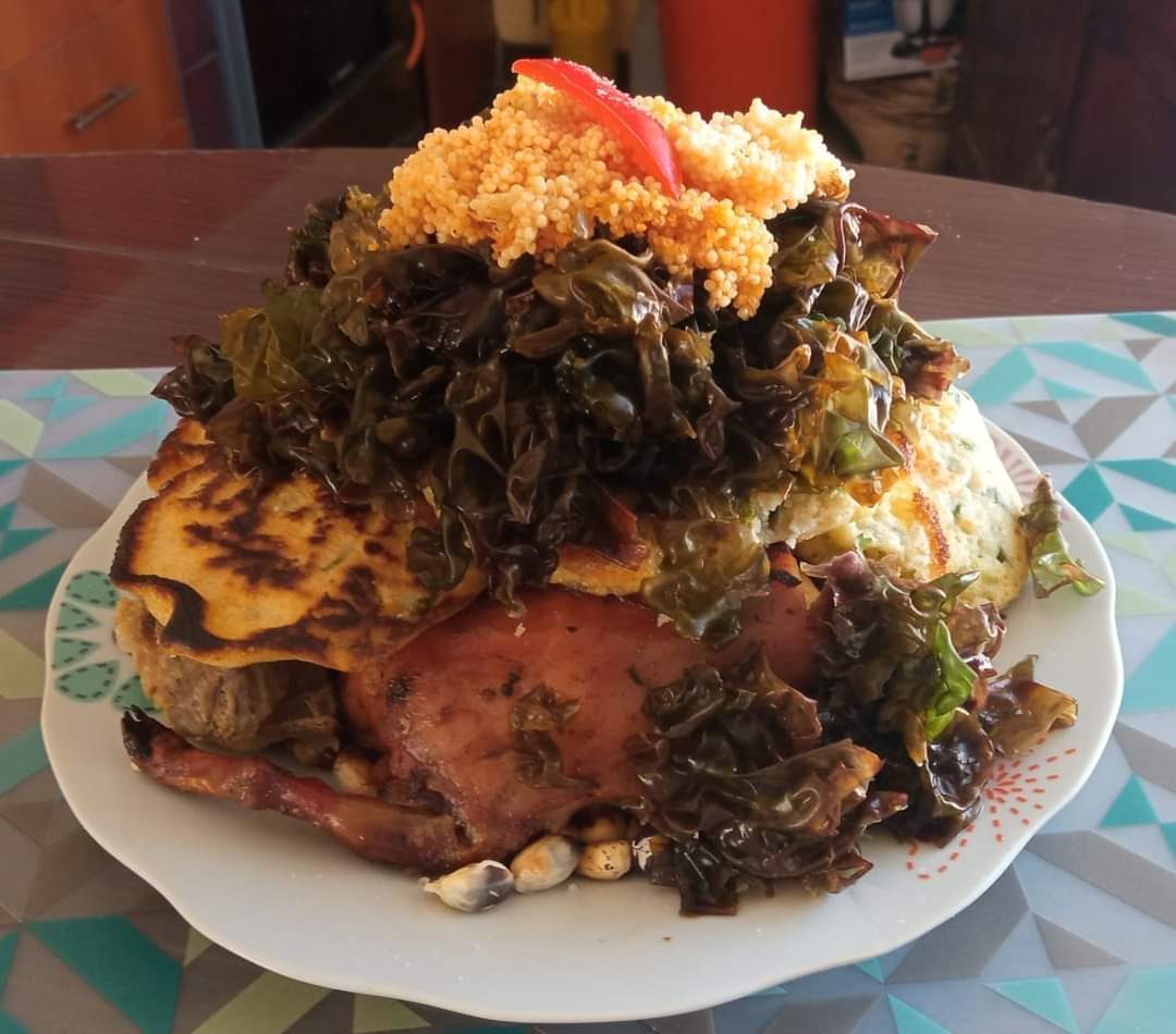 A chiriuchu platter served cold, layered with cochayuyo seaweed, fish roe, corn tortilla, cancha and roasted meat