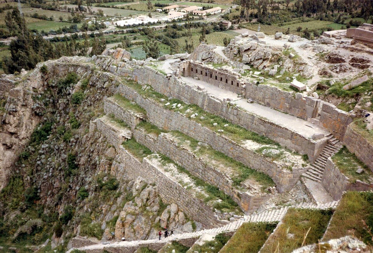 Inca stone terraces and walls climbing the hillside above the town of Ollantaytambo in the Sacred Valley