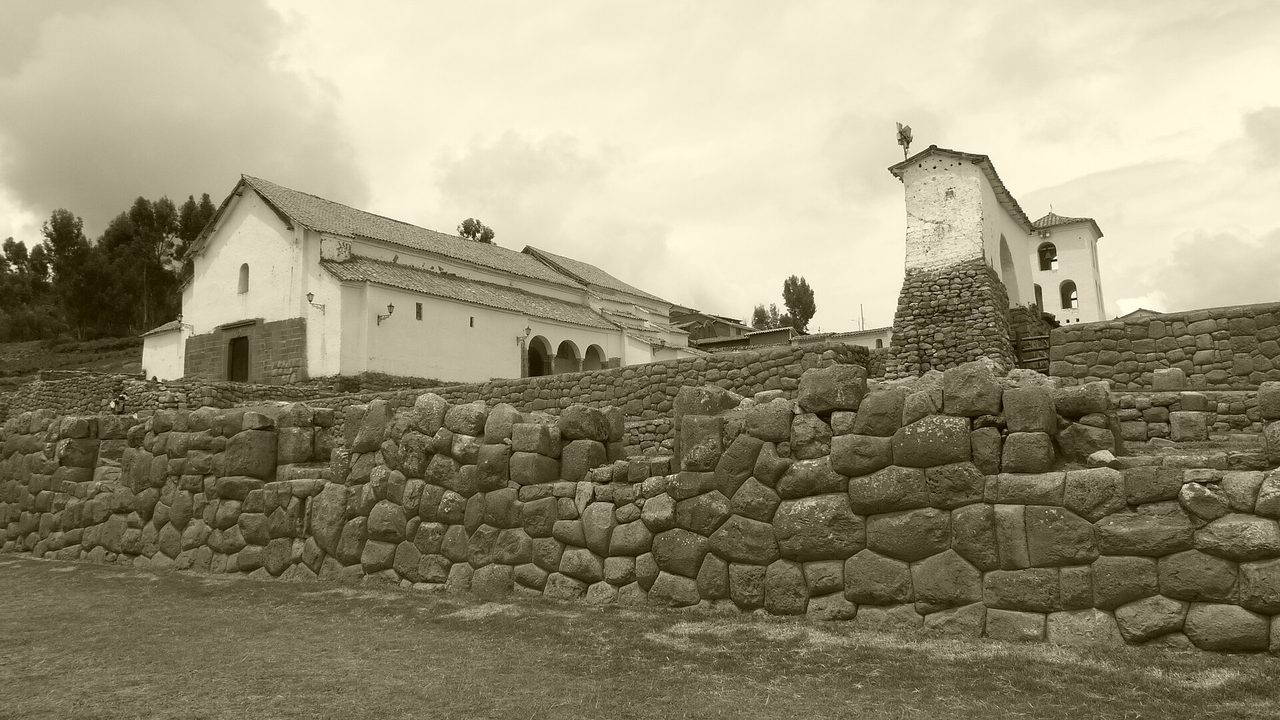 The whitewashed colonial church at Chinchero in the Sacred Valley, built directly on top of a massive Inca terrace wall of fitted stone blocks