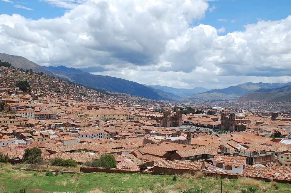 Cusco's tiled roofs and churches filling the floor of its Andean valley at 3,400 m