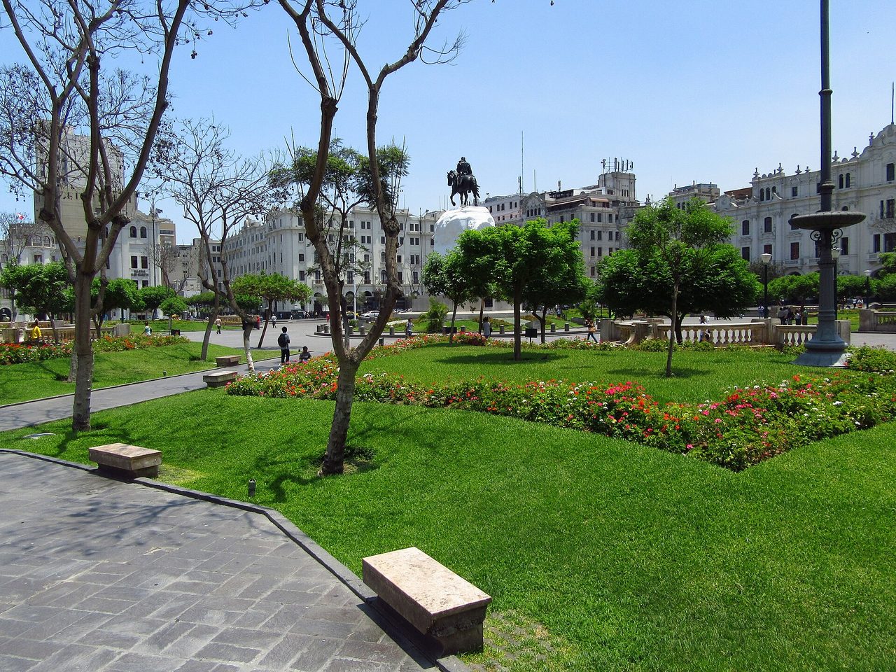 Lawns, flower beds and the equestrian statue of San Martin in Plaza San Martin, central Lima, ringed by cream-coloured early 20th-century buildings