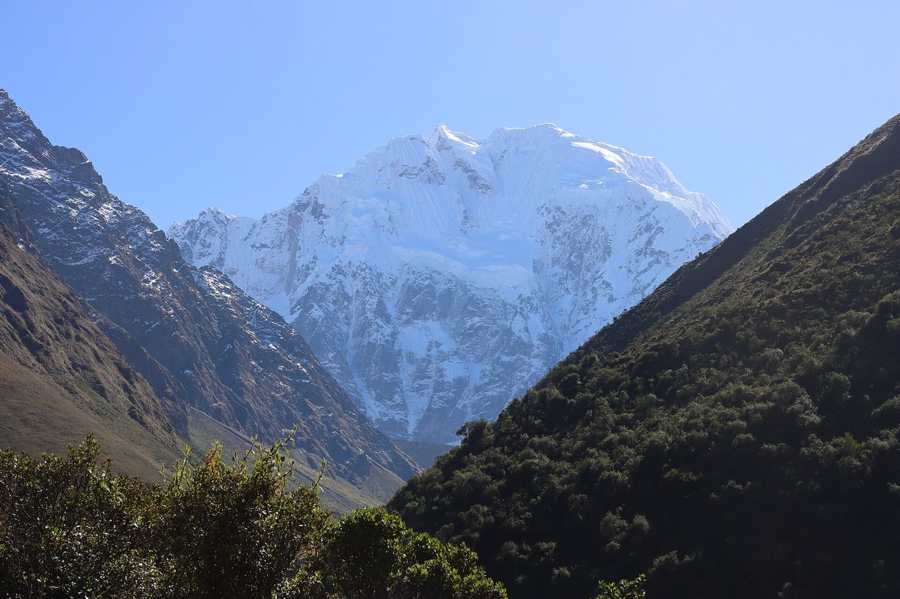 A heavily glaciated peak of the Cordillera Vilcabamba seen up the valley from the approach road, with scrub in the foreground