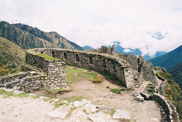 The oval stone walls of Runkurakay, a small Inca tambo on the Inca Trail between the first and second passes, with cloud filling the valley behind