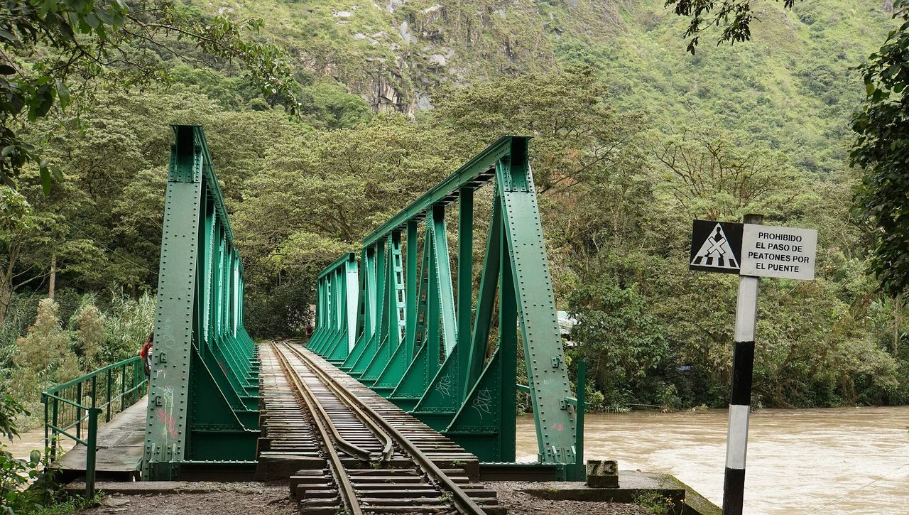 The green steel railway bridge on the Hidroelectrica to Aguas Calientes line, with a sign warning pedestrians not to cross on the track deck