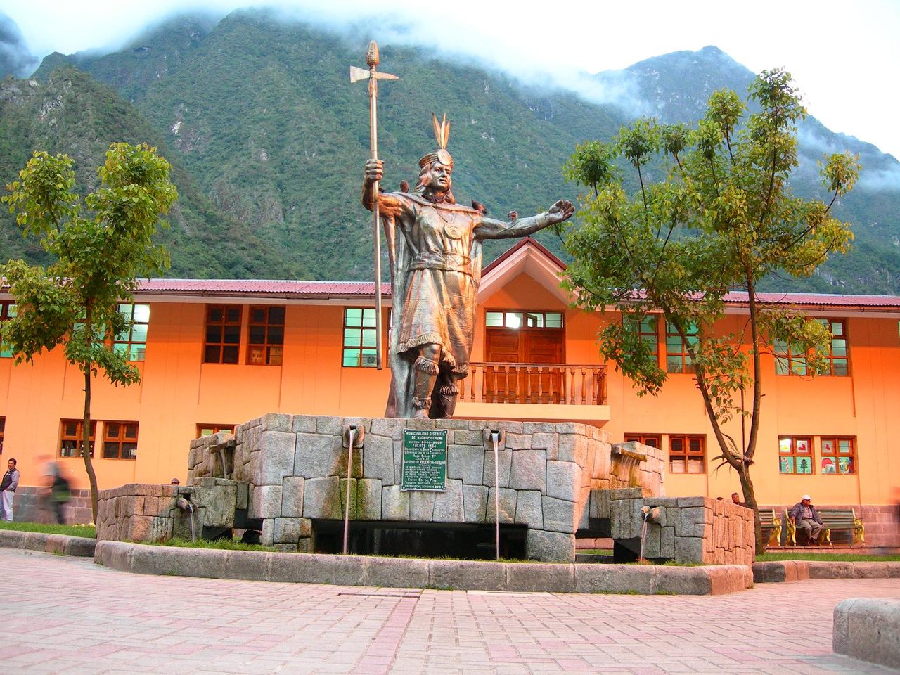 The bronze Inca figure on the stone fountain in the main square of Aguas Calientes, in front of the district municipality building