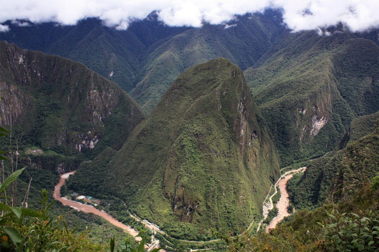 The Urubamba river looping through the gorge far below Machu Picchu, with the valley road and railway running along the floor