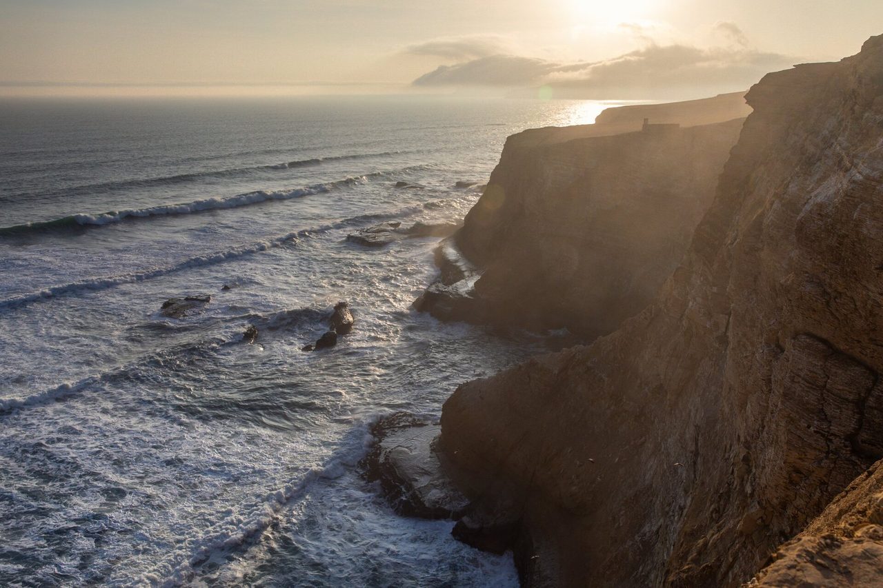 Desert cliffs dropping to breaking Pacific surf on the Paracas peninsula, Peru's south coast