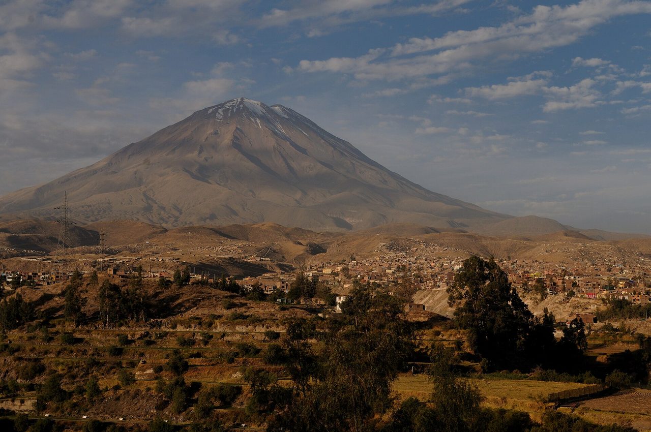 The city of Arequipa under clear blue sky with the snow-dusted cone of El Misti volcano rising behind it