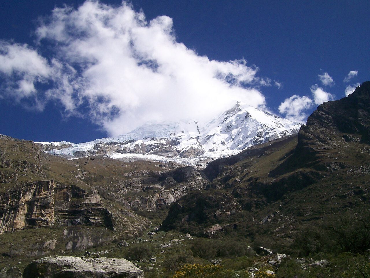 The snow-covered summit of Huascaran rising above rocky slopes in Peru's Cordillera Blanca