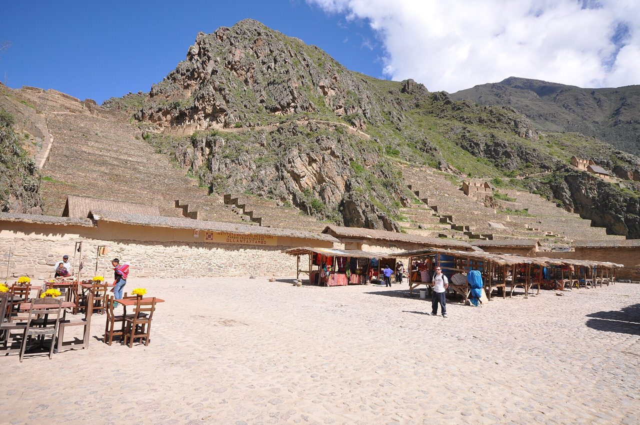 Inca terraces rising above the craft market stalls in the main plaza at Ollantaytambo in Peru's Sacred Valley