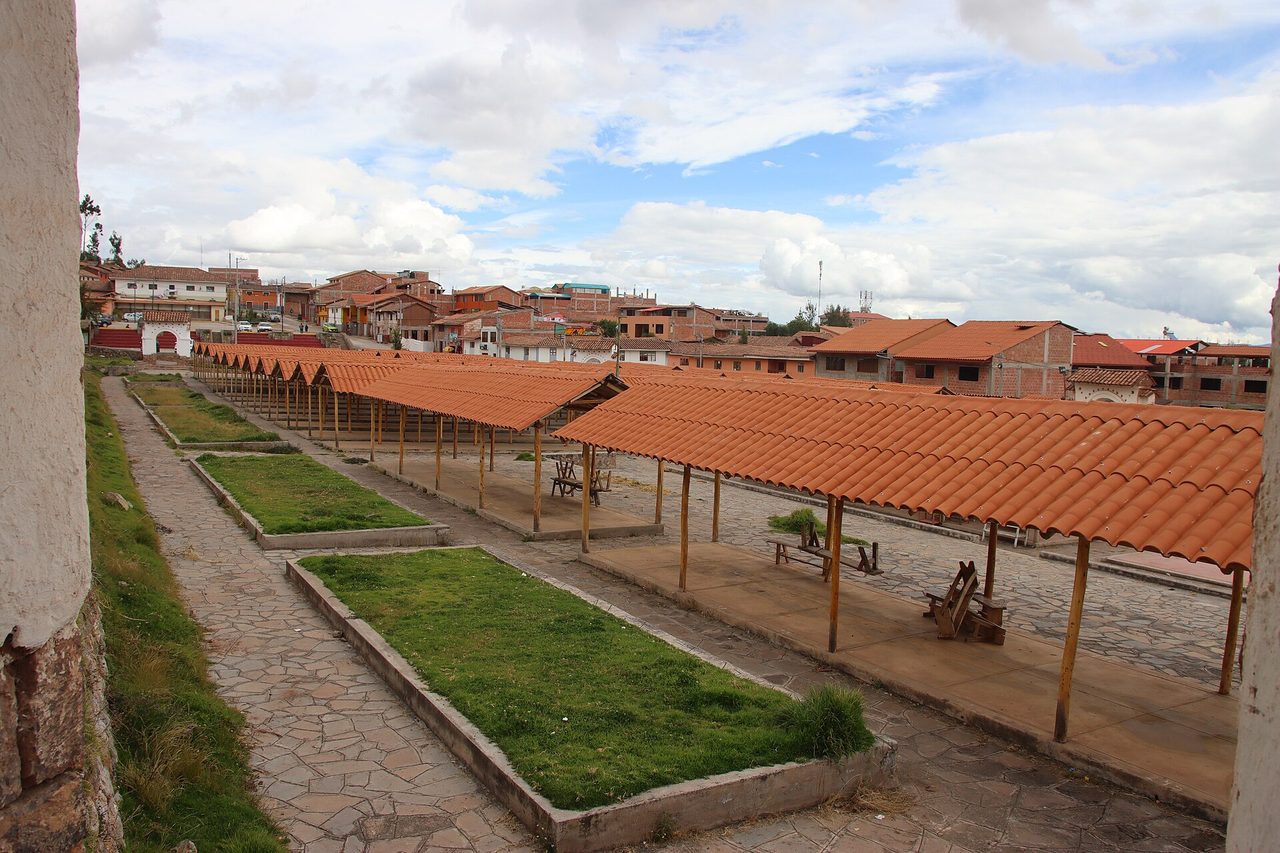 Empty tile-roofed market stalls beside the church in Chinchero on a non-market day