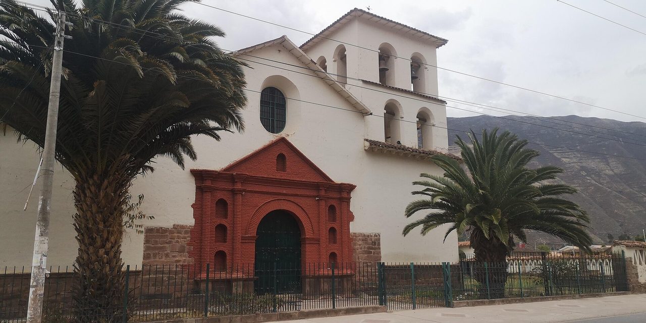 The white colonial church of Santiago Apostol in Yucay, with its red brick portal and open belfry