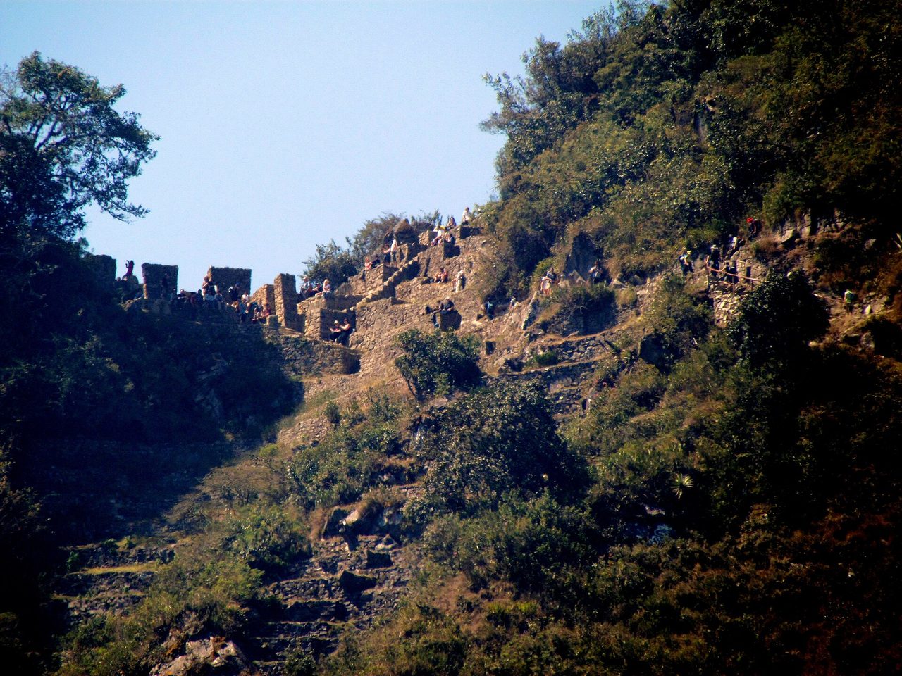 Visitors on the stone ruins of the Inti Punku Sun Gate on the ridge above Machu Picchu