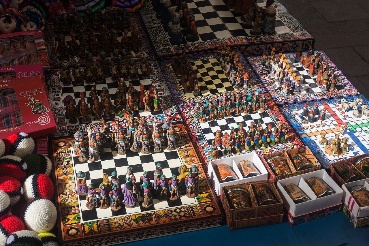 Hand-painted Inca-themed chess sets and other souvenirs laid out on a stall at the Pisac artisan market