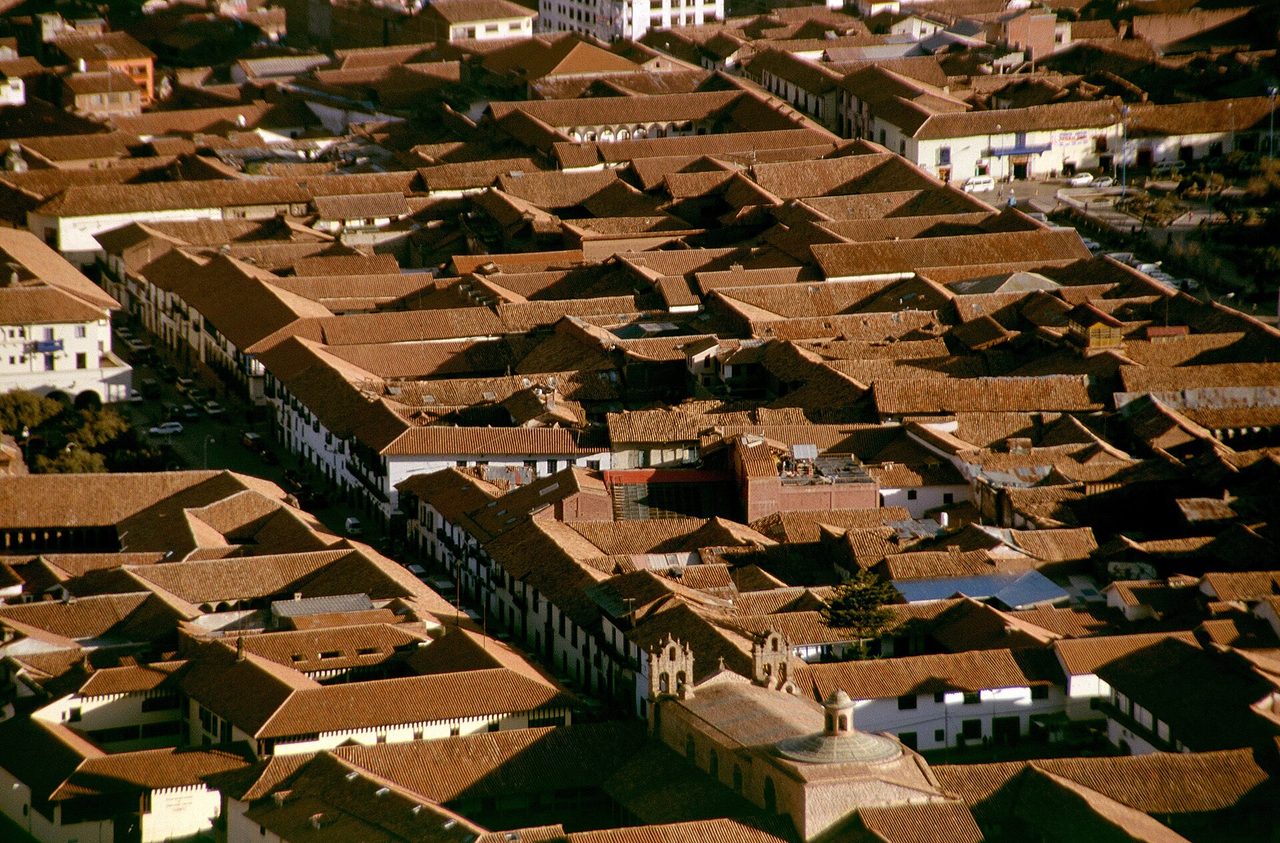 Terracotta tiled rooftops packed across the historic centre of Cusco, seen from above