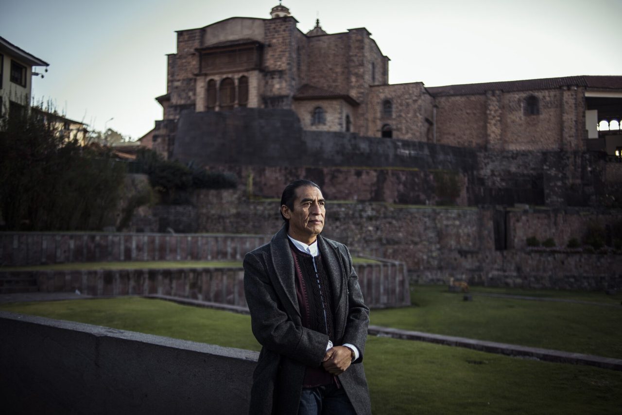 Peruvian tapestry artist Maximo Laura standing in front of the Qoricancha in Cusco