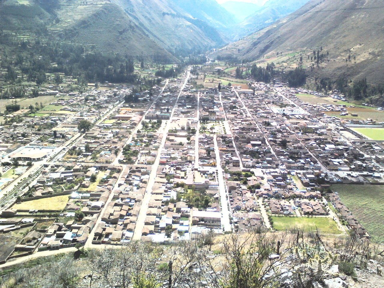 The town of Calca seen from the slope above, its grid of streets and tiled roofs filling the valley floor